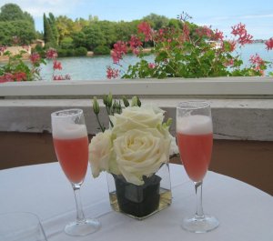 Drinks in fluted glasses with a floral centerpiece overlooking a lagoon as part of a travel bucket list