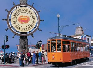 orange trolley in san francisco with fisherman's wharf sign with crab on it